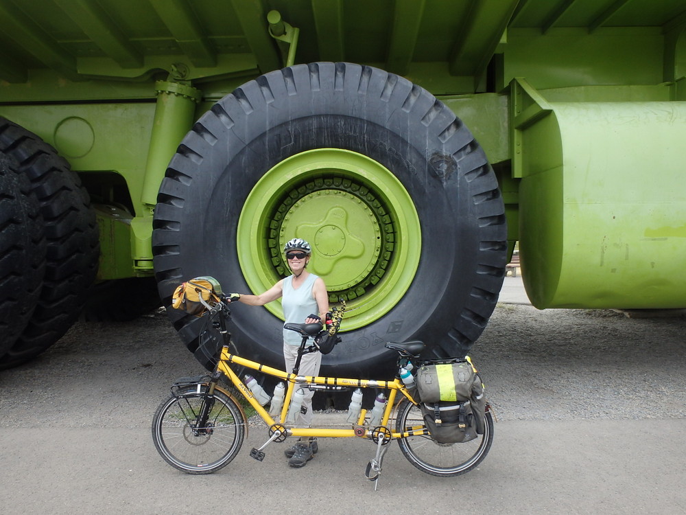 GDMBR: Size Perspective, Terry Struck and the Bee next to the Tire of the World's Largest Truck.