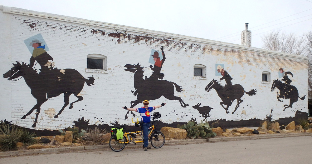 Dennis Struck and the Bee next a building mural in Carrizozo, New Mexico (Photo by Terry).